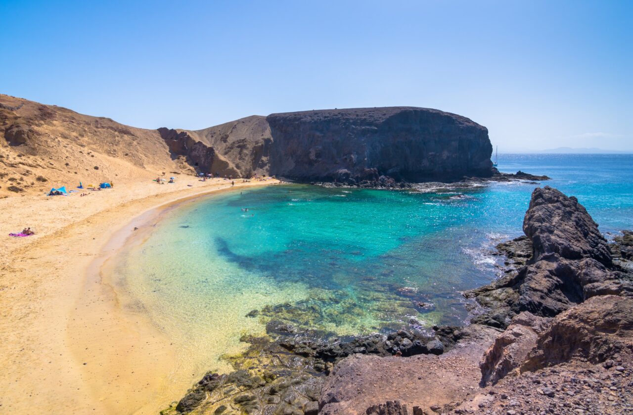 La sabbia chiara e l’acqua turchese di Playa de Papagayo sotto la scogliera