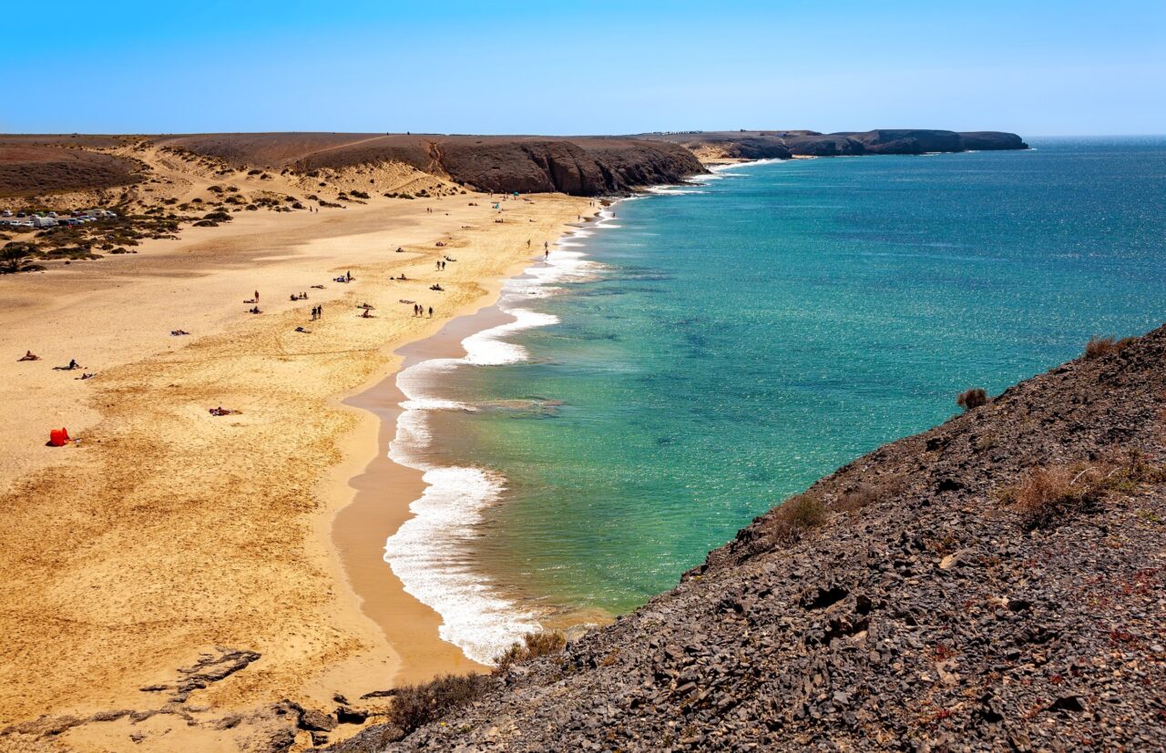 Le onde basse sulla sabbia di Playa Mujeres, viste dalla collina